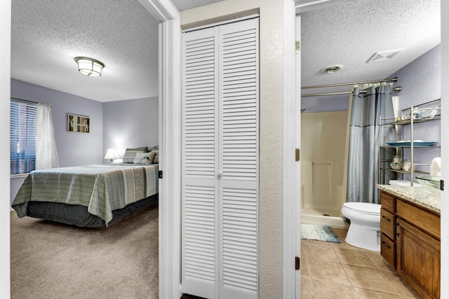 150 Sunken Forest Dr Unit 10-253, Forsyth, MO 65653 - bedroom featuring a textured ceiling, a closet, light tile patterned floors, connected bathroom, and a textured wall
