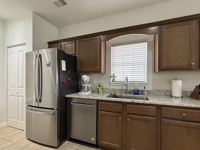 330 S Wildwood Dr Unit B1, Branson, MO 65616 - kitchen featuring stainless steel appliances, light tile patterned floors, light stone countertops, and dark brown cabinets