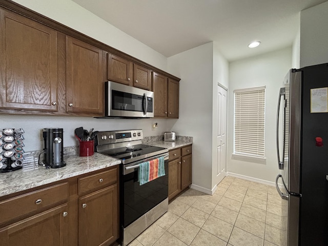 330 S Wildwood Dr Unit B1, Branson, MO 65616 - kitchen with appliances with stainless steel finishes, light tile patterned floors, light stone countertops, dark brown cabinetry, and recessed lighting