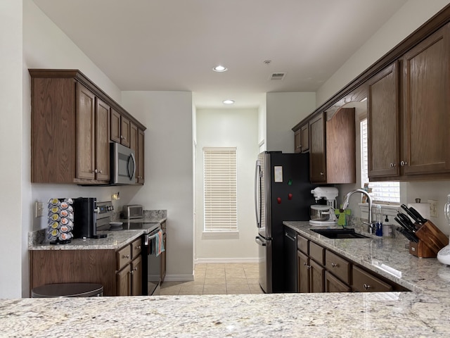 330 S Wildwood Dr Unit B1, Branson, MO 65616 - kitchen featuring stainless steel appliances, light stone counters, light tile patterned flooring, recessed lighting, and dark brown cabinetry