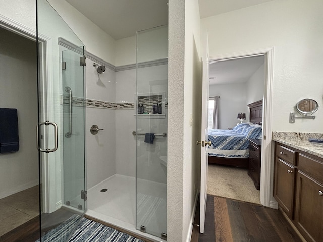 330 S Wildwood Dr Unit B1, Branson, MO 65616 - bathroom featuring ensuite bath, a stall shower, vanity, and wood finished floors