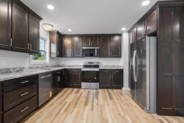 407 W Adamson St, Miller, MO 65707 - kitchen featuring stainless steel appliances, light wood-style floors, dark brown cabinetry, recessed lighting, and light stone countertops