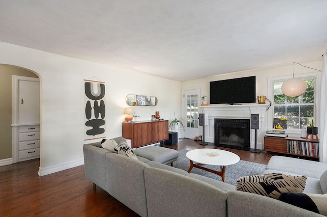 223 E Silsby St, Springfield, MO 65807 - living room with a fireplace, dark wood-style flooring, and arched walkways