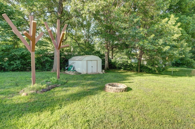 223 E Silsby St, Springfield, MO 65807 - view of green lawn with a storage shed, an outdoor fire pit, and view of wooded area