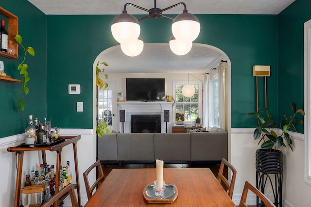 223 E Silsby St, Springfield, MO 65807 - dining space featuring arched walkways, a fireplace, and a wainscoted wall