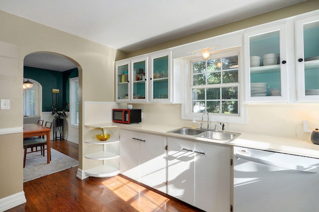 223 E Silsby St, Springfield, MO 65807 - kitchen with white dishwasher, arched walkways, dark wood finished floors, white cabinets, and light countertops