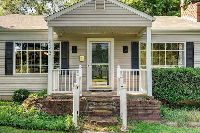 223 E Silsby St, Springfield, MO 65807 - entrance to property featuring a porch, roof with shingles, and a chimney