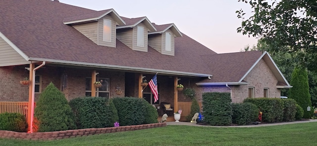 106 Finch Dr, Strafford, MO 65757 - view of front of house featuring a front lawn, brick siding, covered porch, and roof with shingles
