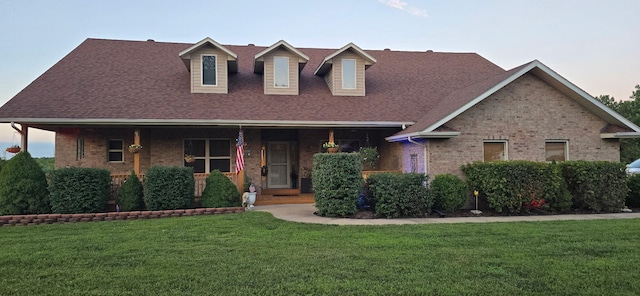 106 Finch Dr, Strafford, MO 65757 - view of front facade featuring a front yard, brick siding, a shingled roof, and covered porch