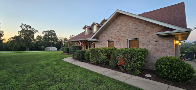 106 Finch Dr, Strafford, MO 65757 - view of property exterior featuring a lawn, brick siding, roof with shingles, and an outdoor structure