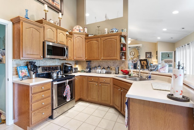 106 Finch Dr, Strafford, MO 65757 - kitchen with stainless steel appliances, decorative backsplash, light countertops, light tile patterned floors, and a peninsula