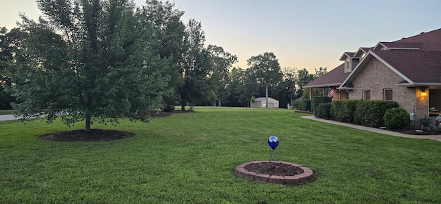 106 Finch Dr, Strafford, MO 65757 - yard at dusk featuring a yard and a storage unit