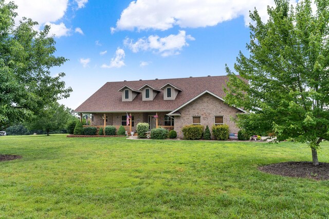 106 Finch Dr, Strafford, MO 65757 - new england style home featuring covered porch, brick siding, and a front yard