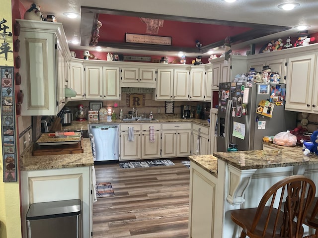 4811 State Route Cc, West Plains, MO 65775 - kitchen with stainless steel appliances, light stone countertops, a peninsula, light wood finished floors, and a kitchen breakfast bar