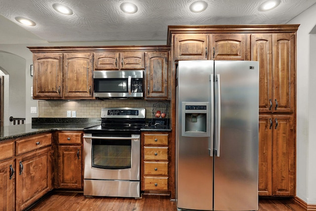 623 E Weaver Rd, Springfield, MO 65810 - kitchen featuring stainless steel appliances, dark wood-type flooring, decorative backsplash, recessed lighting, and dark stone countertops