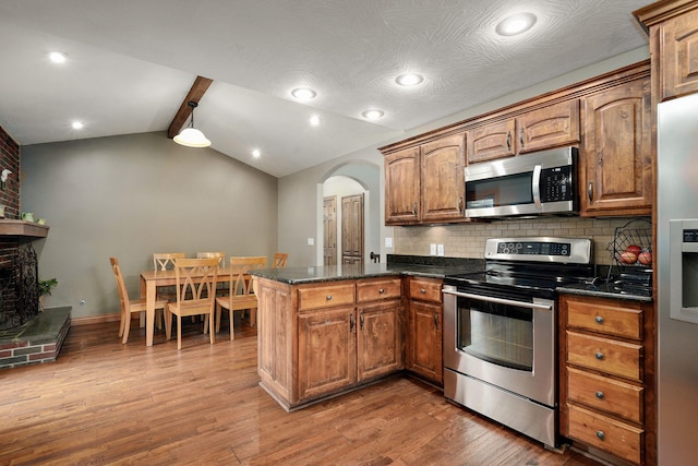 623 E Weaver Rd, Springfield, MO 65810 - kitchen featuring stainless steel appliances, a peninsula, wood finished floors, backsplash, and arched walkways