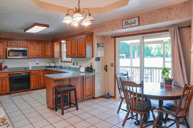 258 State Highway 32, Buffalo, MO 65622 - kitchen featuring black appliances, a peninsula, brown cabinetry, wallpapered walls, and a chandelier