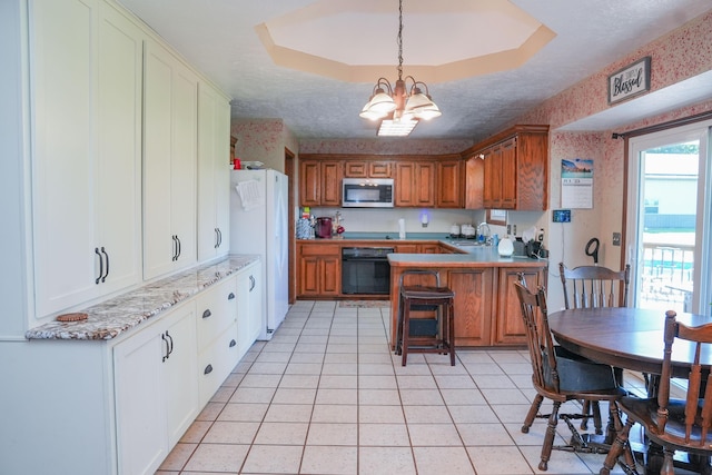 258 State Highway 32, Buffalo, MO 65622 - kitchen with stainless steel microwave, freestanding refrigerator, a peninsula, brown cabinetry, and oven