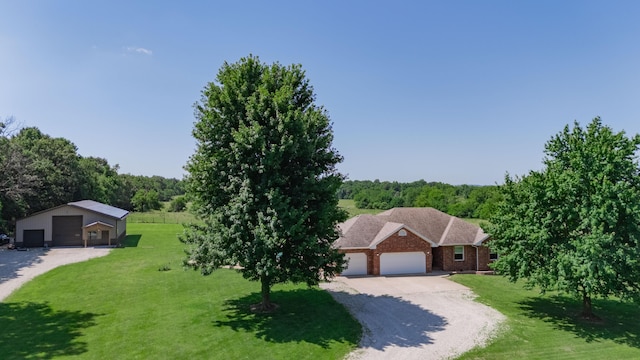 258 State Highway 32, Buffalo, MO 65622 - view of front facade with a front yard, a view of trees, brick siding, a garage, and driveway
