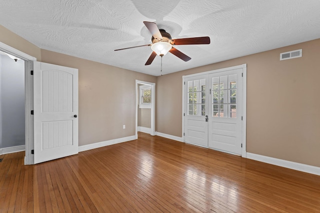 1201 N Broadway Ave, Springfield, MO 65802 - unfurnished bedroom with wood-type flooring, multiple windows, ceiling fan, and a textured ceiling