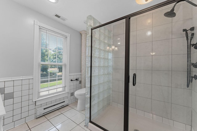 1201 N Broadway Ave, Springfield, MO 65802 - full bath featuring tile walls, baseboard heating, a wainscoted wall, tile patterned floors, and a shower stall