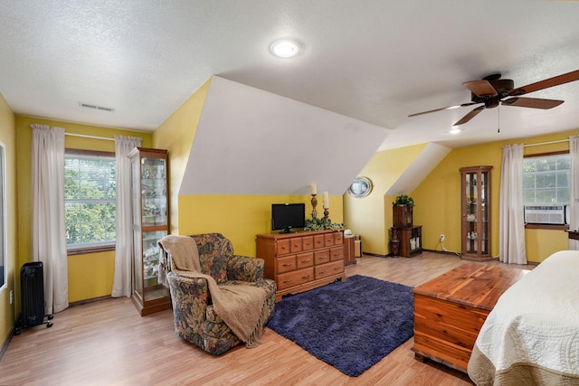 12655 Lawrence Unit 2155, Mount Vernon, MO 65712 - bedroom with radiator, multiple windows, wood finished floors, lofted ceiling, and a textured ceiling