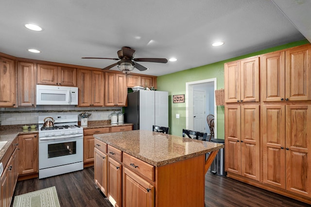 12655 Lawrence Unit 2155, Mount Vernon, MO 65712 - kitchen with white appliances, dark wood finished floors, decorative backsplash, a kitchen island, and recessed lighting