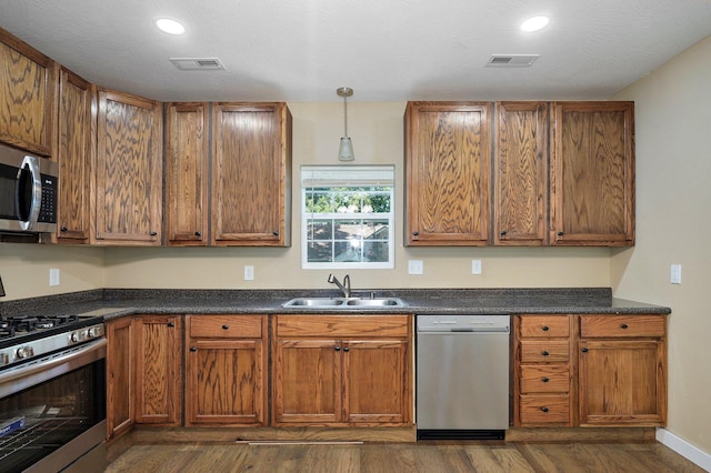 114 N Hobbs St, Miller, MO 65707 - kitchen with stainless steel appliances, dark wood-type flooring, dark countertops, brown cabinets, and recessed lighting