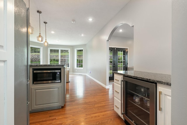 295 Headwaters Dr, Marshfield, MO 65706 - kitchen featuring beverage cooler, stainless steel appliances, light wood finished floors, arched walkways, and recessed lighting