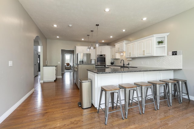 295 Headwaters Dr, Marshfield, MO 65706 - kitchen with stainless steel appliances, arched walkways, white cabinetry, open shelves, and recessed lighting