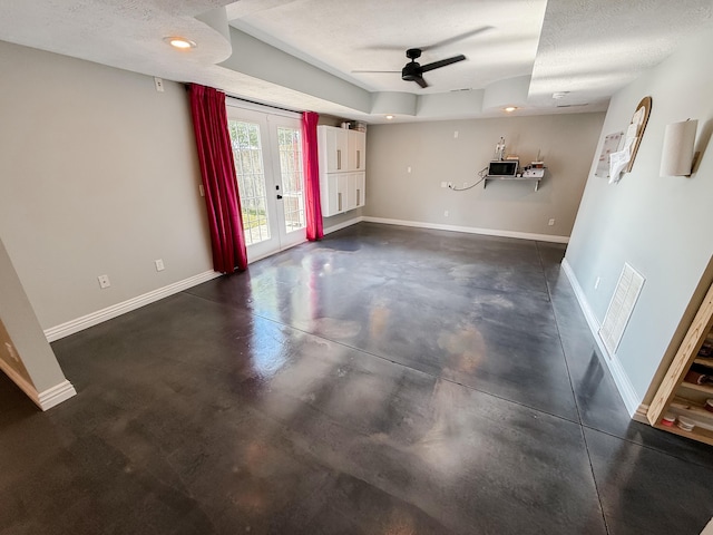 295 Headwaters Dr, Marshfield, MO 65706 - unfurnished living room featuring ceiling fan, french doors, concrete flooring, a raised ceiling, and a textured ceiling