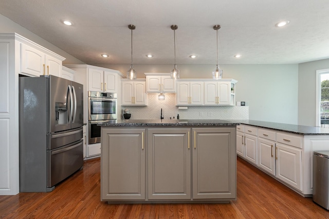 295 Headwaters Dr, Marshfield, MO 65706 - kitchen with appliances with stainless steel finishes, white cabinetry, decorative backsplash, a peninsula, and dark wood finished floors