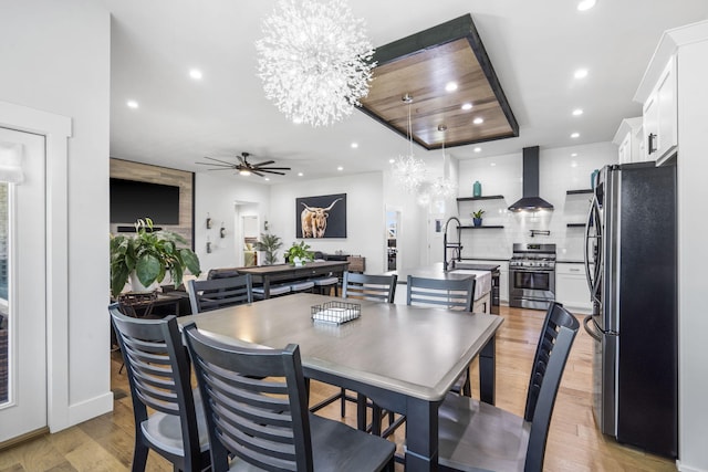 940 E Powers Ct, Nixa, MO 65714 - dining room with recessed lighting, light wood-style flooring, ceiling fan, a chandelier, and a raised ceiling