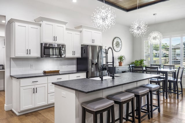 940 E Powers Ct, Nixa, MO 65714 - kitchen featuring appliances with stainless steel finishes, a chandelier, dark countertops, dark wood finished floors, and backsplash