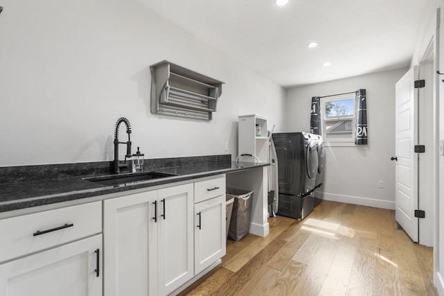 940 E Powers Ct, Nixa, MO 65714 - kitchen with independent washer and dryer, light wood-style floors, white cabinetry, recessed lighting, and dark stone counters