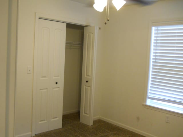 424 Echo Valley Cir, Reeds Spring, MO 65737 - unfurnished bedroom featuring dark carpet, a closet, and ceiling fan