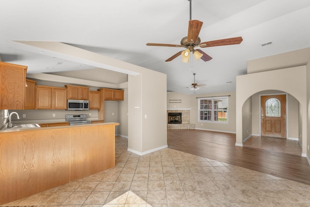 663 N Althea Ave, Nixa, MO 65714 - kitchen with stainless steel appliances, lofted ceiling, a ceiling fan, arched walkways, and a peninsula