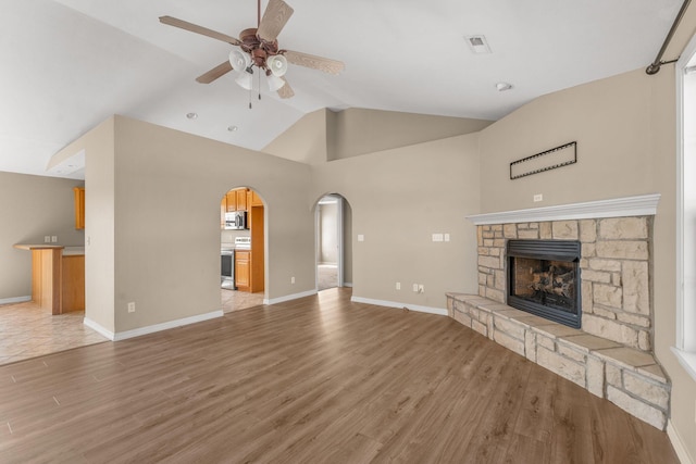 663 N Althea Ave, Nixa, MO 65714 - unfurnished living room featuring ceiling fan, arched walkways, a fireplace, light wood-type flooring, and high vaulted ceiling