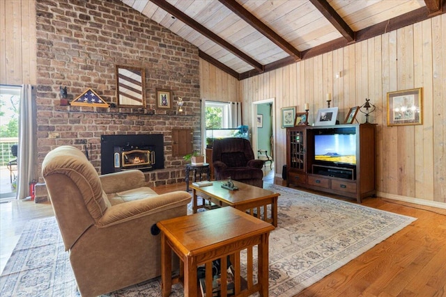 23 Sweetwater Ln, Buffalo, MO 65622 - living area featuring a brick fireplace, wood walls, a wood ceiling with exposed beams, wood finished floors, and high vaulted ceiling