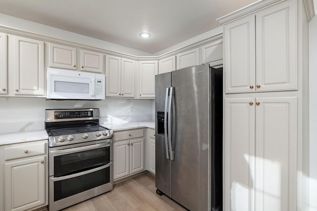 903 N 4th St, Ozark, MO 65721 - kitchen featuring appliances with stainless steel finishes, light wood-type flooring, light stone counters, and recessed lighting