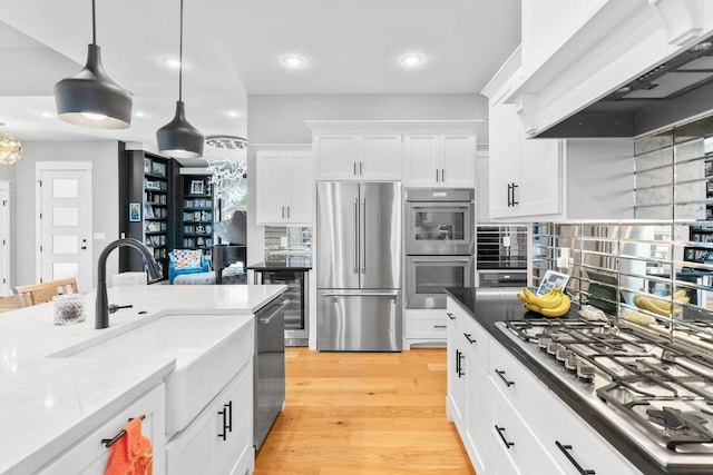 3972 E Dunrobin Dr, Springfield, MO 65809 - kitchen featuring appliances with stainless steel finishes, premium range hood, recessed lighting, white cabinetry, and pendant lighting