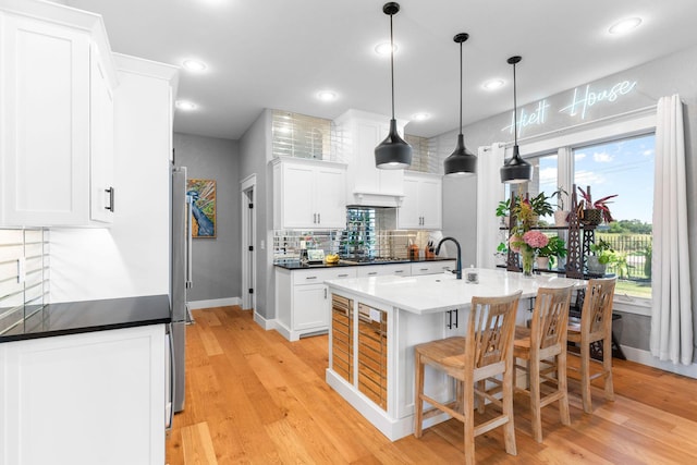 3972 E Dunrobin Dr, Springfield, MO 65809 - kitchen with backsplash, white cabinets, light wood-style flooring, a kitchen breakfast bar, and recessed lighting
