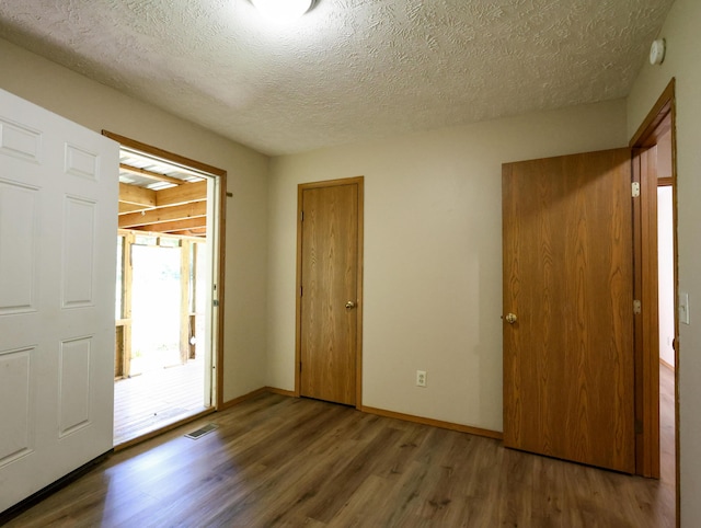 1324 N Forest Ave, Springfield, MO 65802 - unfurnished bedroom featuring wood finished floors, a textured ceiling, and a closet