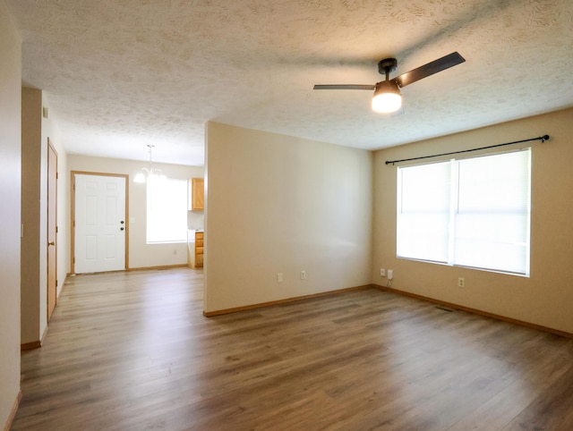 1324 N Forest Ave, Springfield, MO 65802 - unfurnished room featuring a textured ceiling, light wood finished floors, ceiling fan, and a chandelier