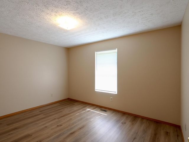 1324 N Forest Ave, Springfield, MO 65802 - spare room featuring light wood-type flooring and a textured ceiling