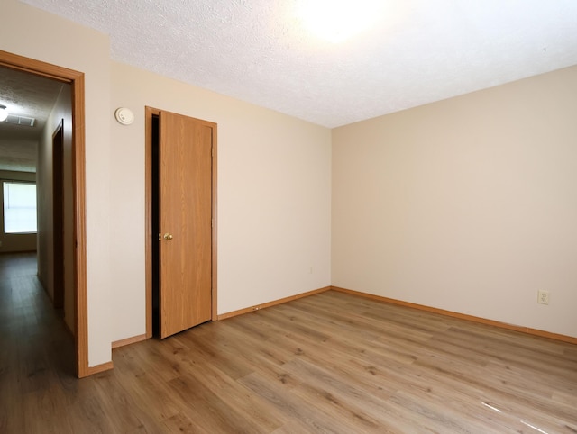 1324 N Forest Ave, Springfield, MO 65802 - spare room with light wood-style flooring, a textured ceiling, and a smoke detector
