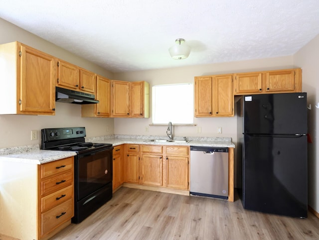 1324 N Forest Ave, Springfield, MO 65802 - kitchen featuring black appliances, under cabinet range hood, and light wood-type flooring