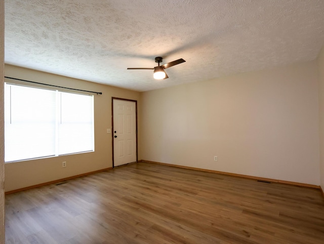 1324 N Forest Ave, Springfield, MO 65802 - spare room with a textured ceiling, light wood-style flooring, and a ceiling fan