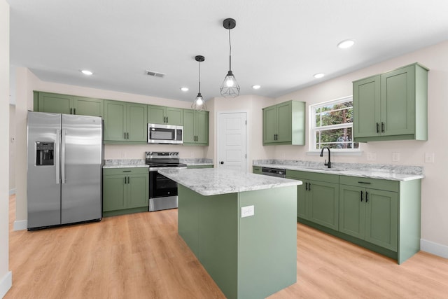 265 Mccann Rd, Powersite, MO 65731 - kitchen with appliances with stainless steel finishes, green cabinets, light wood-style floors, hanging light fixtures, and a kitchen island