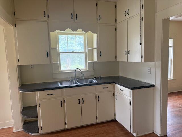 714 W Leyda Ave, West Plains, MO 65775 - kitchen with wood finished floors, dark countertops, and white cabinetry